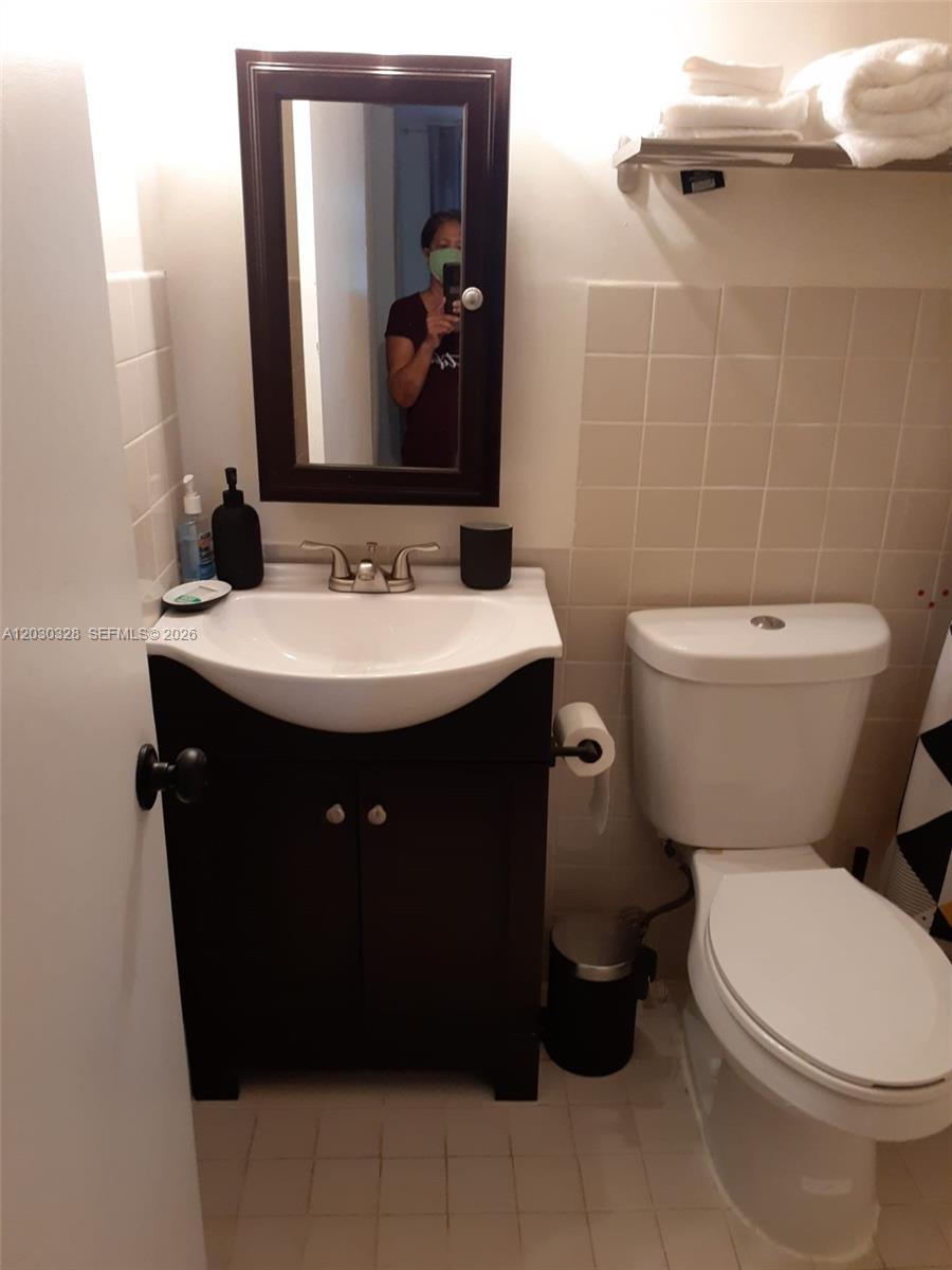 A bathroom features a dark wood vanity, a white sink, and a toilet — 2306 Sunshine Blvd, Miramar FL 33023, MIRAMAR, FL