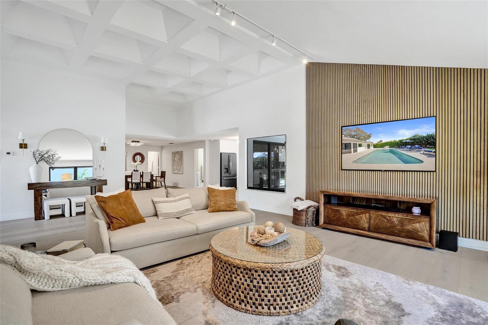 A living room features a coffered ceiling, a wood-slat accent wall, and a round coffee table — 614 Lakewoode Circle W, Delray Beach FL 33445, DELRAY BEACH, FL