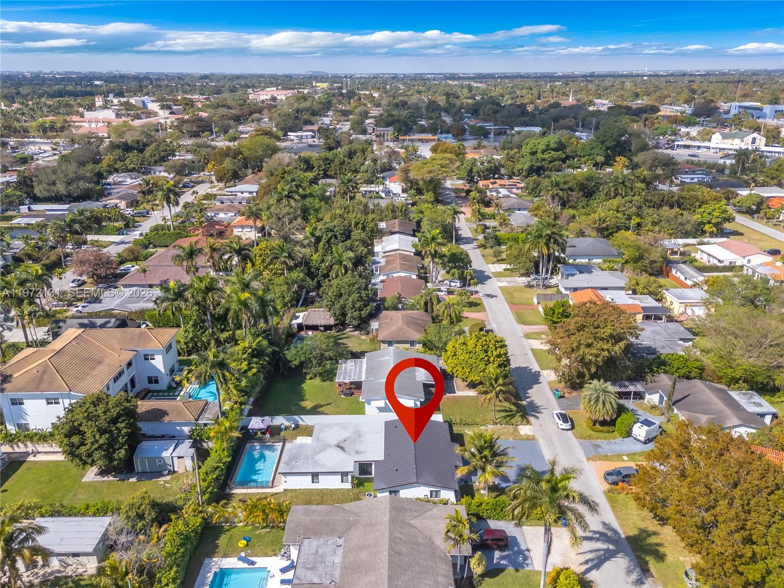 An aerial view shows a residential neighborhood with houses, swimming pools, and palm trees — 348 NE 117th St, Miami FL 33161, MIAMI, FL