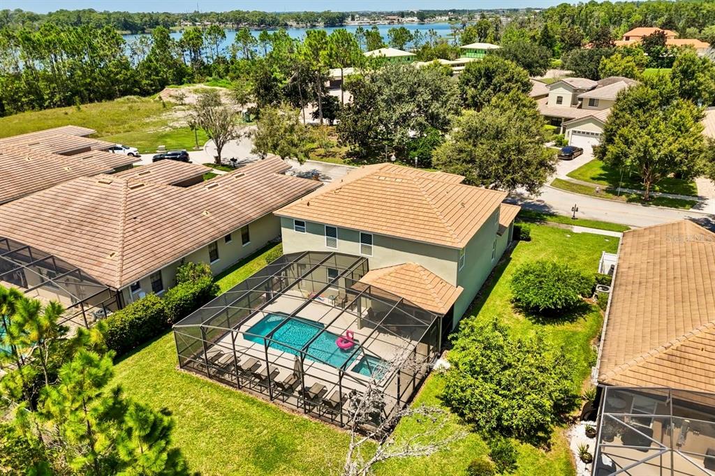 An aerial view shows a two-story house with a screened-in pool and patio area — 9128 STROMBOLI COURT, KISSIMMEE, FL