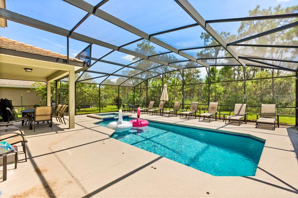 A screened-in patio features a swimming pool, a hot tub, and outdoor seating — 9128 STROMBOLI COURT, KISSIMMEE, FL