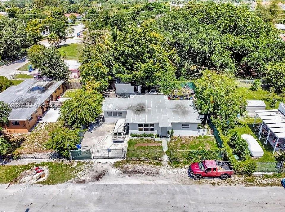 An aerial view shows a single-story house with a flat roof, driveway, and fenced yard — 261 NW 73rd Ter, Miami FL 33150, MIAMI, FL