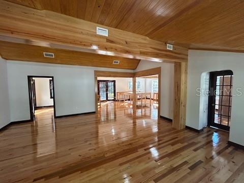A spacious room features polished wood flooring and exposed wood ceiling beams — 1027 NW 11TH AVENUE, GAINESVILLE, FL
