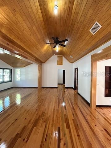 A spacious room features vaulted wood-paneled ceilings, hardwood floors, and a ceiling fan — 1027 NW 11TH AVENUE, GAINESVILLE, FL