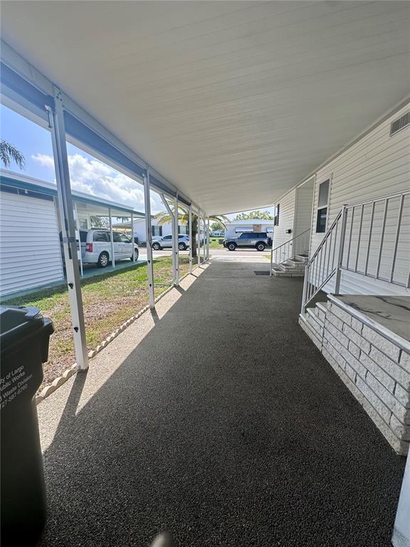 A living room features brown sofas, a wooden coffee table, and a large compass wall decoration — 1100 BELCHER ROAD S UNIT 406, LARGO, FL