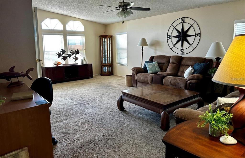 A kitchen with white cabinets, a round wooden dining table, and light wood-look flooring — 1100 BELCHER ROAD S UNIT 406, LARGO, FL