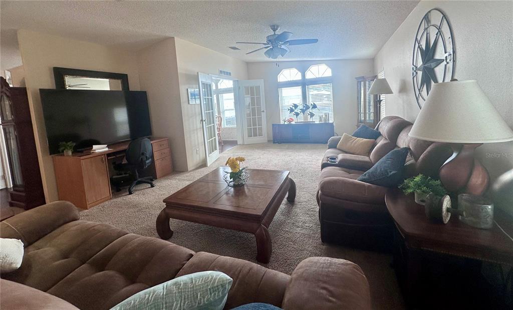 A kitchen features white cabinets, a gray countertop, white appliances, and light wood-look flooring — 1100 BELCHER ROAD S UNIT 406, LARGO, FL
