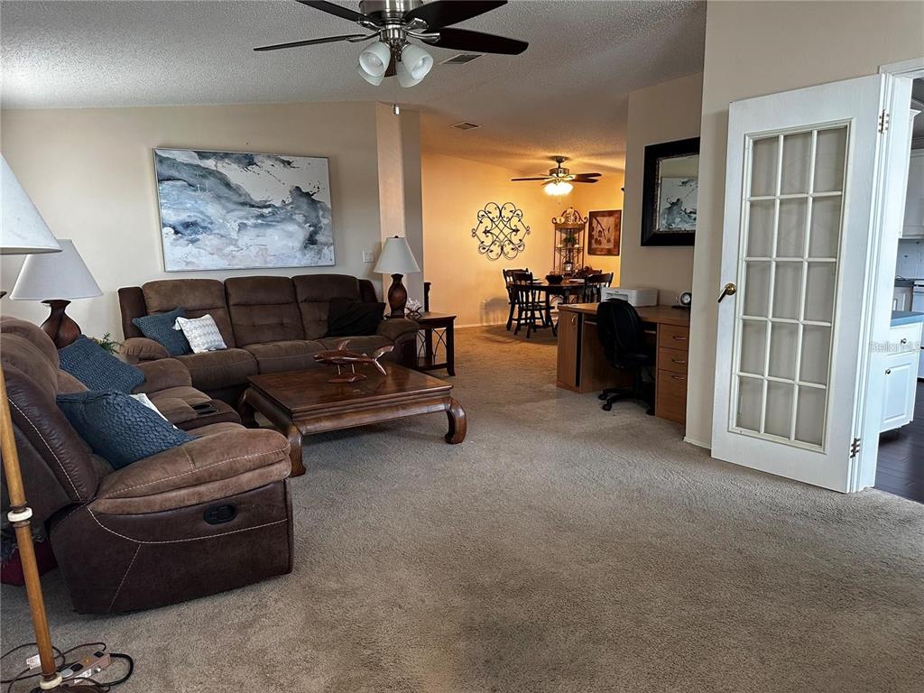 A kitchen features white cabinetry, a white refrigerator, a stove, and light wood-look flooring — 1100 BELCHER ROAD S UNIT 406, LARGO, FL