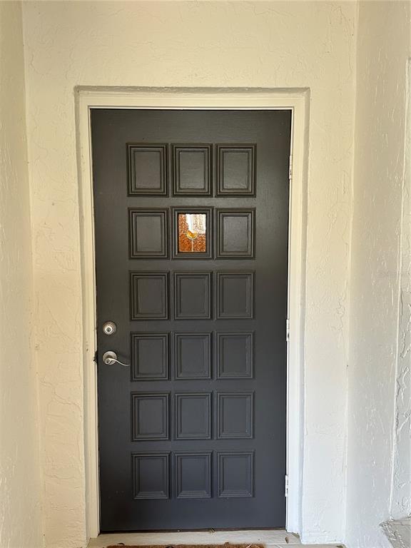 A dark gray front door with a single small decorative window pane and recessed panels — 760 AVENIDA ESTANCIA UNIT 217, VENICE, FL