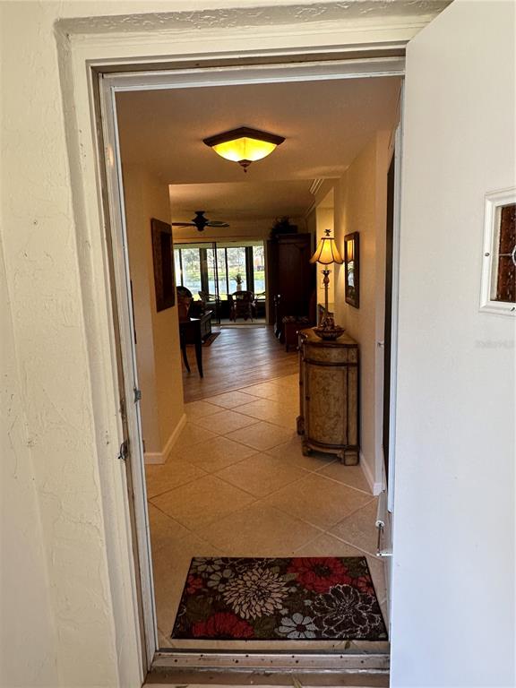 An entryway leads into a tiled living area with a view of a lake — 760 AVENIDA ESTANCIA UNIT 217, VENICE, FL