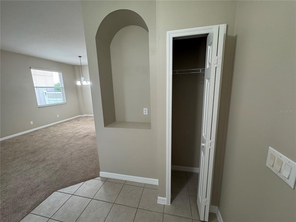A tiled entryway leads to a carpeted living area with a closet and arched wall niche — 5004 ADAIR OAK DRIVE, ORLANDO, FL