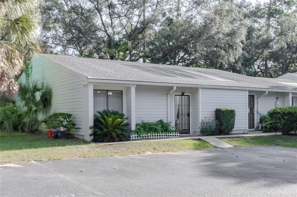 A single-story residential building with light-colored siding, a shingled roof, and a paved parking area — 3063 NW 28TH CIRCLE, GAINESVILLE, FL
