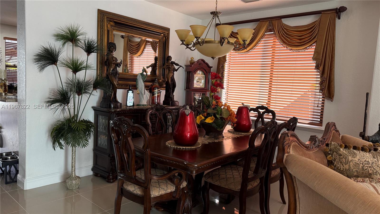 A formal dining room features a dark wood table, ornate chairs, and a grandfather clock — 14431 SW 22nd Ter, Miami FL 33175, MIAMI, FL
