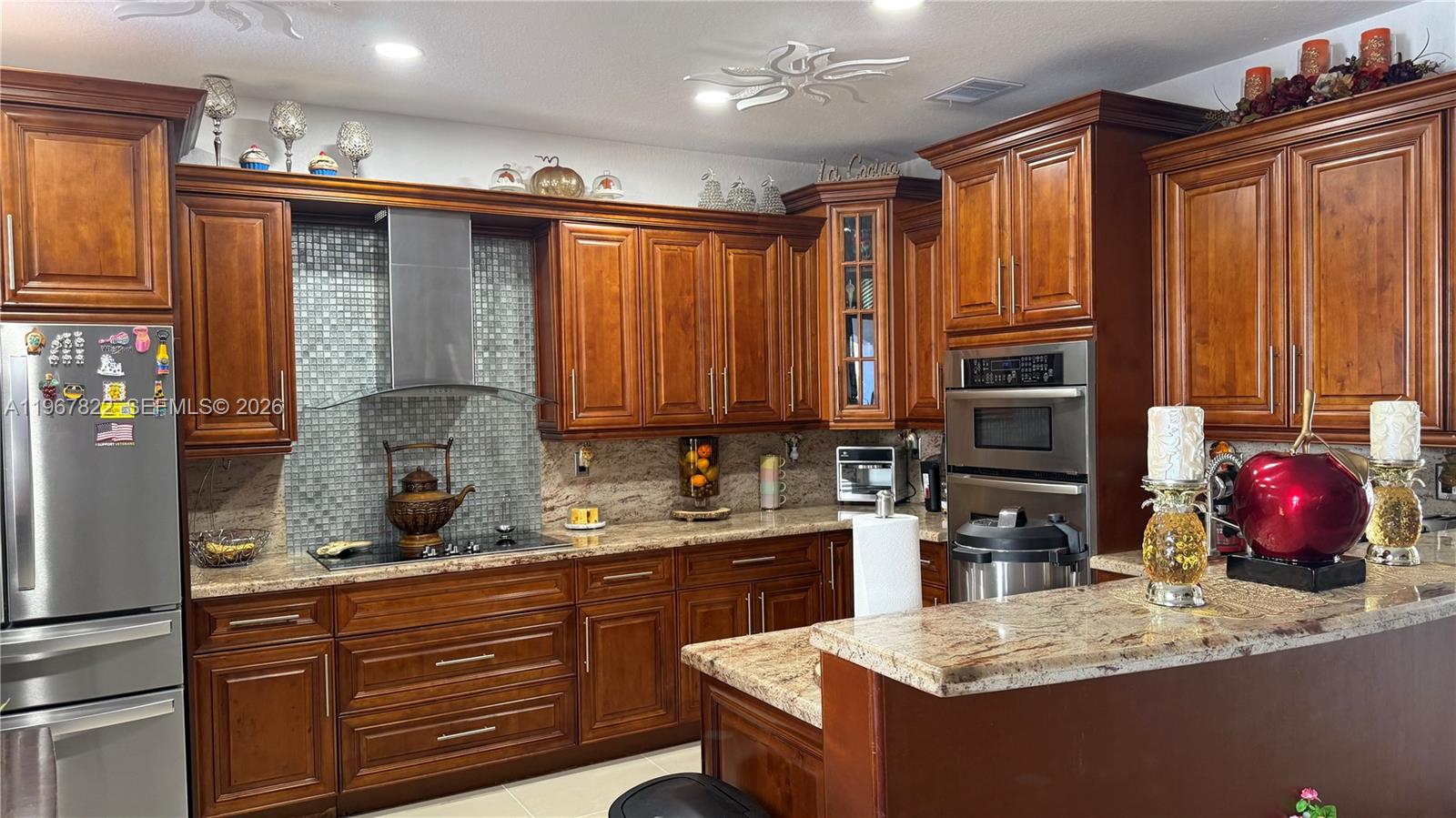 A kitchen features wood cabinets, granite countertops, stainless steel appliances, and a tiled backsplash — 14431 SW 22nd Ter, Miami FL 33175, MIAMI, FL