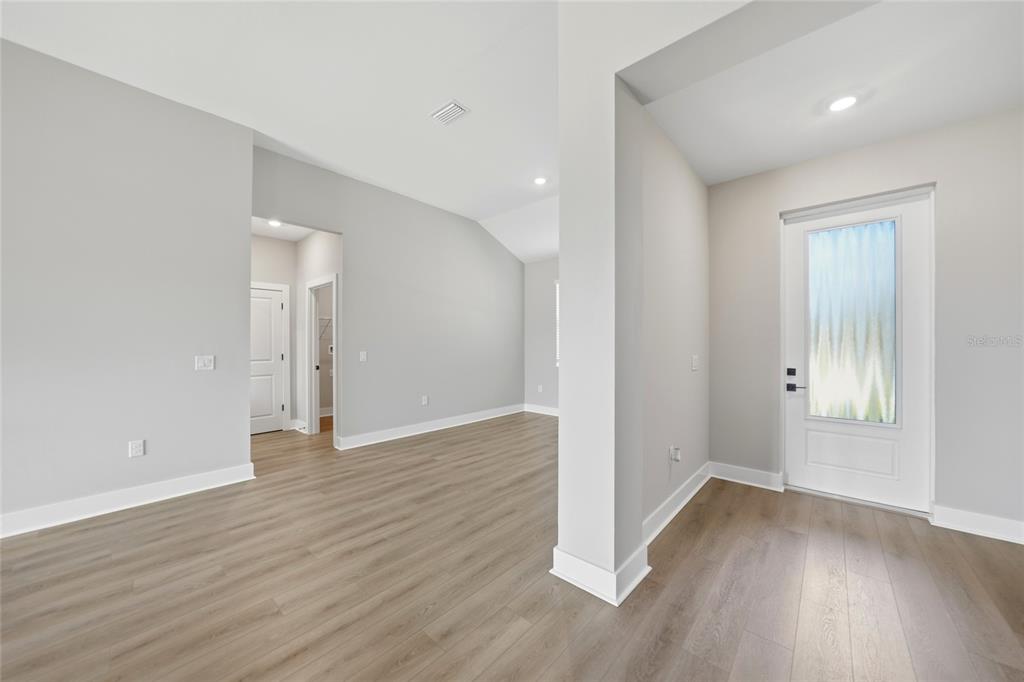 An interior view of a home entryway with light gray walls and wood-look flooring — 5104 MUNHALL STREET, PORT CHARLOTTE, FL