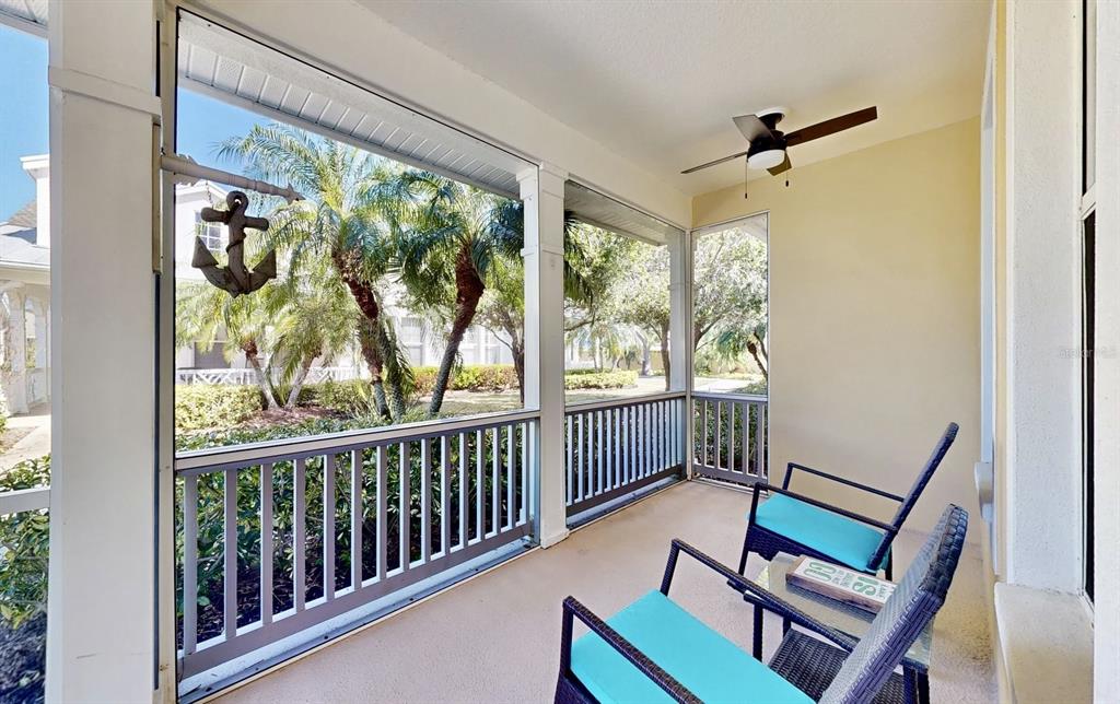 A screened-in porch features two chairs, a small table, and an anchor wall decoration — 203 OCEANIA COURT, APOLLO BEACH, FL