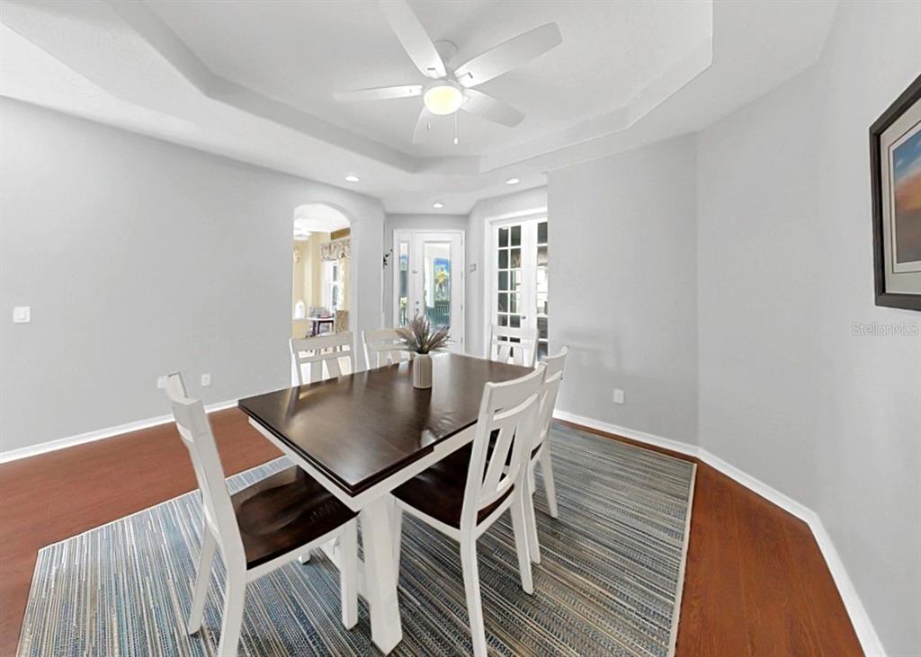 A dining room features a dark wood table, white chairs, and a ceiling fan — 203 OCEANIA COURT, APOLLO BEACH, FL