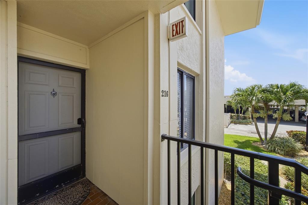 An exterior view of a residential unit entrance with a screen door and unit number — 6322 PALMA DEL MAR BOULEVARD S UNIT 216, ST PETERSBURG, FL