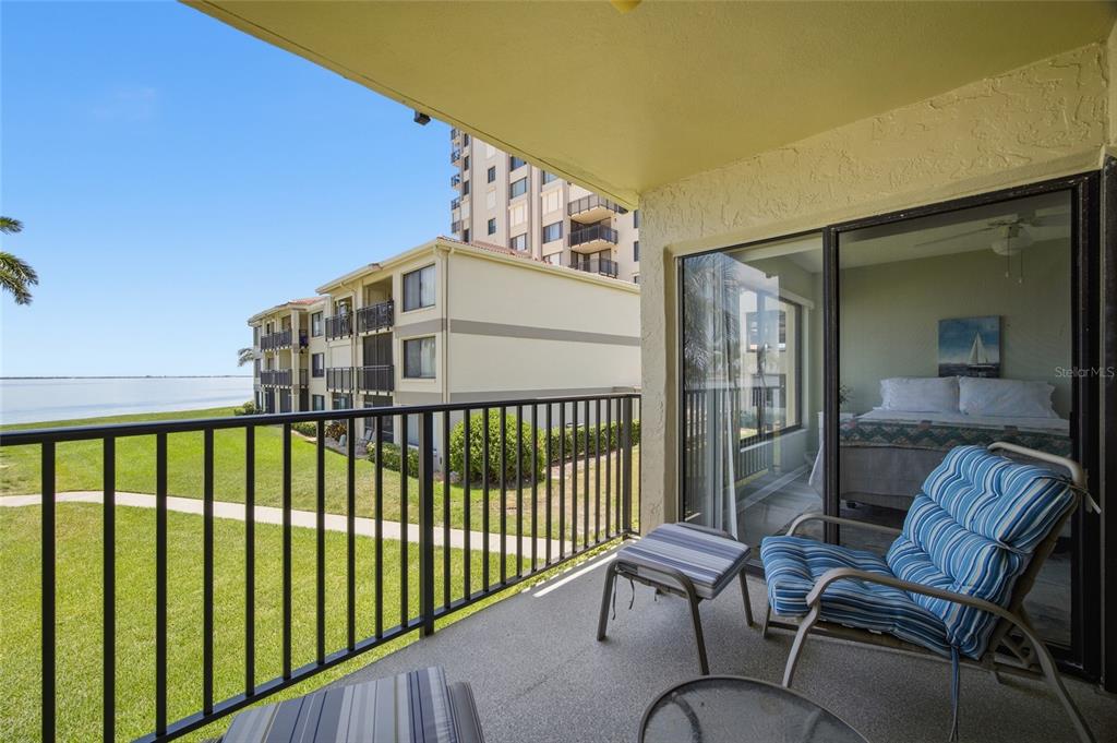A balcony with a metal railing overlooks a grassy lawn and a body of water — 6322 PALMA DEL MAR BOULEVARD S UNIT 216, ST PETERSBURG, FL