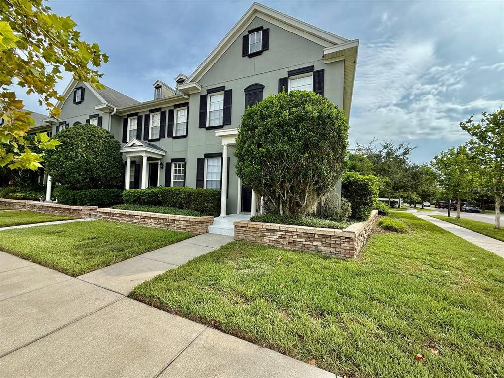 A two-story gray house with black shutters and a stone retaining wall in the front — 10653 MARSHA DRIVE, NEW PORT RICHEY, FL