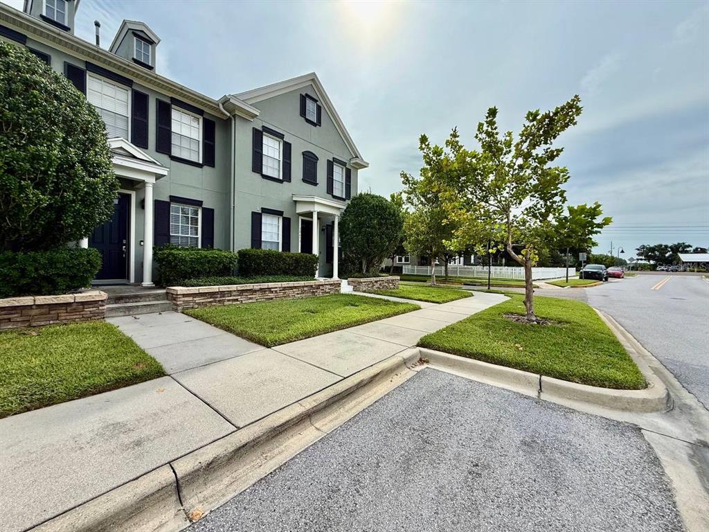 A two-story townhouse with a gray exterior, dark shutters, and a front lawn — 10653 MARSHA DRIVE, NEW PORT RICHEY, FL