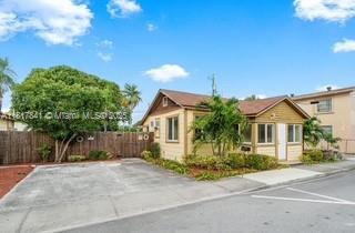 A single-story house with a brown roof and light-colored siding sits next to a driveway — 1416 N 2nd Ave N, Lake Worth FL 33460, LAKE WORTH, FL