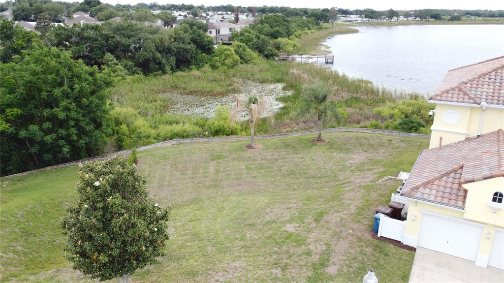 An aerial view shows a house with a large grassy backyard overlooking a lake — 350 CHEROKEE AVE, HAINES CITY, FL