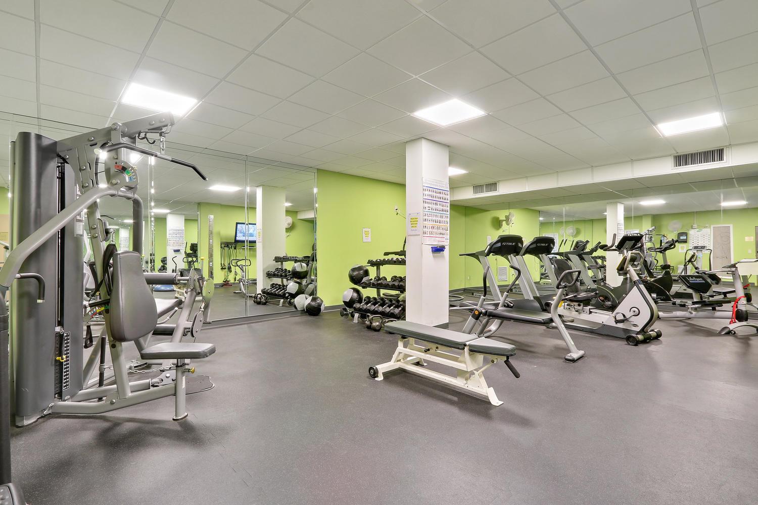 A gym features a multi-station weight machine, dumbbells, cardio equipment, and mirrored walls — 3450 S Ocean Boulevard # 508, Palm Beach FL 33480, PALM BEACH, FL