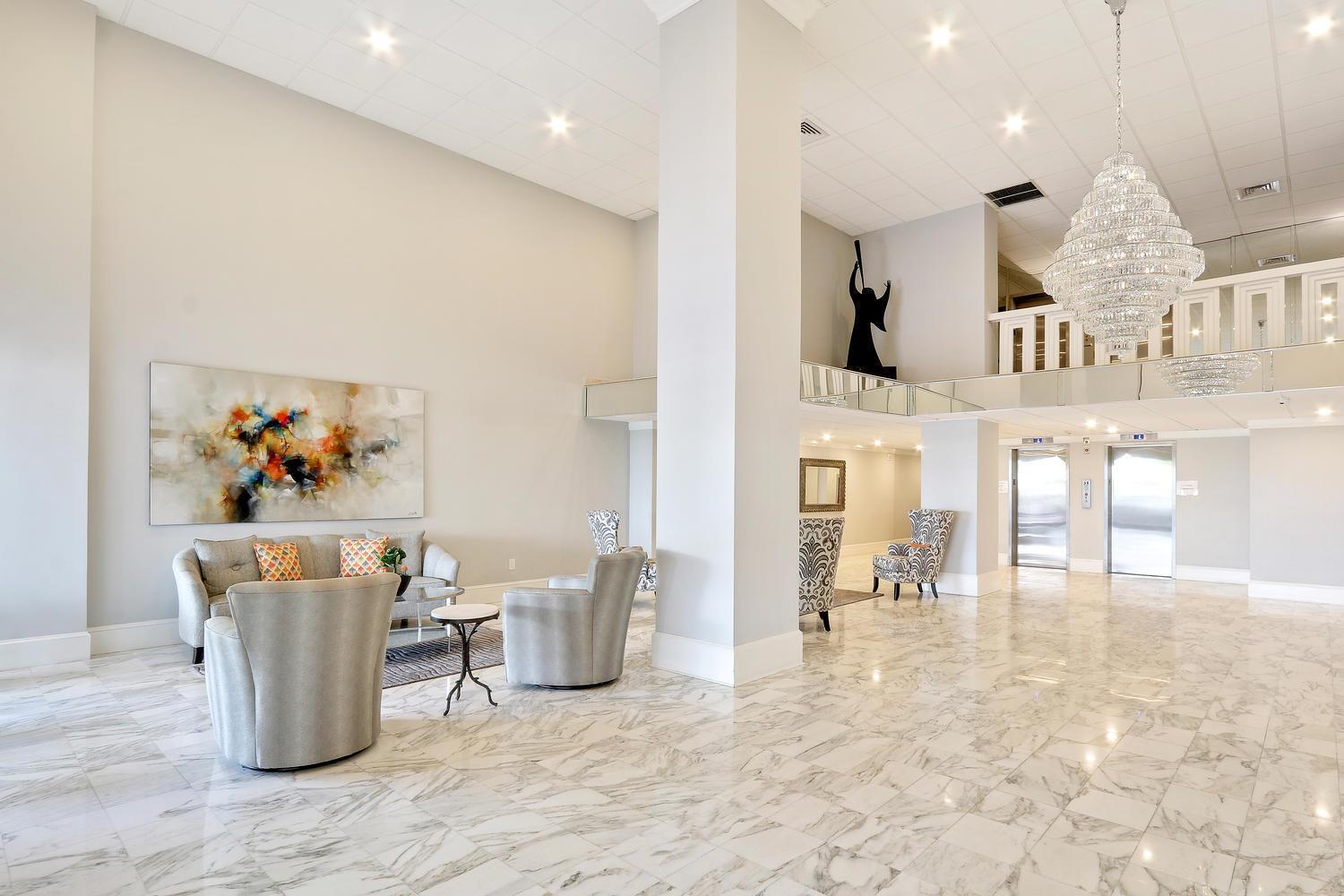 A spacious lobby features marble floors, a large crystal chandelier, and contemporary seating areas — 3450 S Ocean Boulevard # 508, Palm Beach FL 33480, PALM BEACH, FL