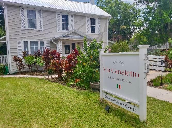 A two-story house with light siding and a sign for an Italian restaurant in front — 317 N ORANGE STREET, NEW SMYRNA BEACH, FL