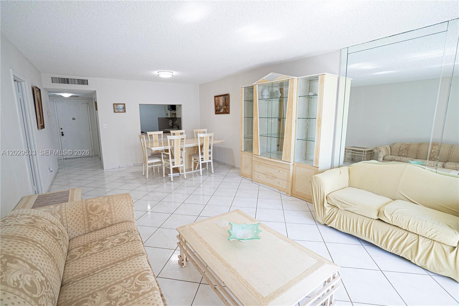 A living and dining area features white tile floors, a light-colored sofa, and a hutch — 600 Three Islands Blvd # 1416, Hallandale Beach FL 33009, HALLANDALE BEACH, FL