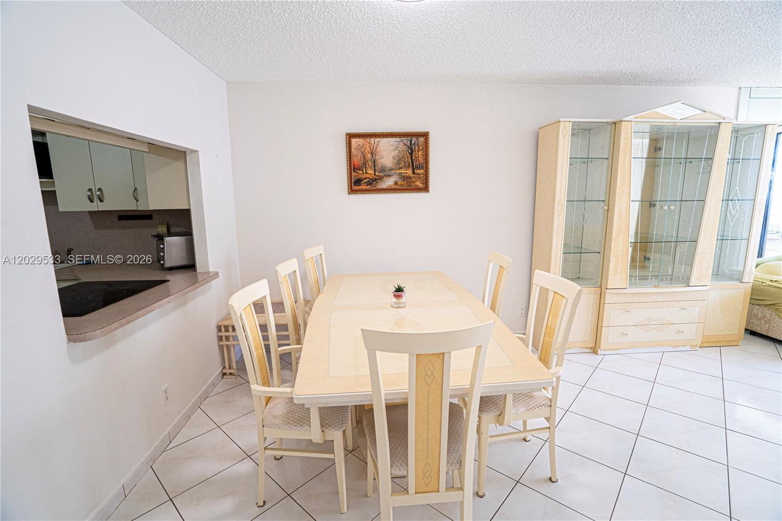 A dining room features a light-colored table with six chairs, tile flooring, and a hutch — 600 Three Islands Blvd # 1416, Hallandale Beach FL 33009, HALLANDALE BEACH, FL