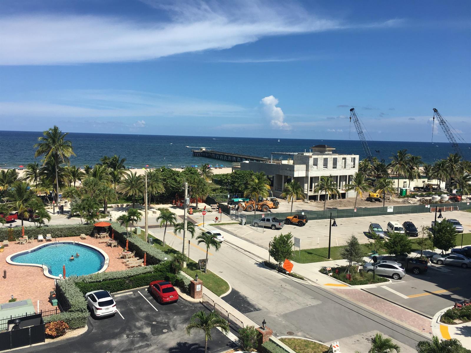 An elevated view shows a swimming pool, a parking lot, and a beach with a pier — 305 N Pompano Beach Boulevard # 606, Pompano Beach FL 33062, POMPANO BEACH, FL