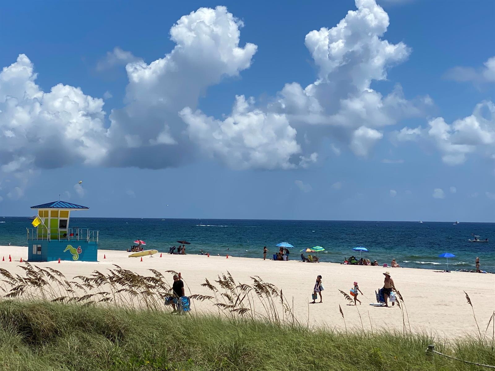 A lifeguard tower stands on a sandy beach under a bright blue sky with clouds — 305 N Pompano Beach Boulevard # 606, Pompano Beach FL 33062, POMPANO BEACH, FL