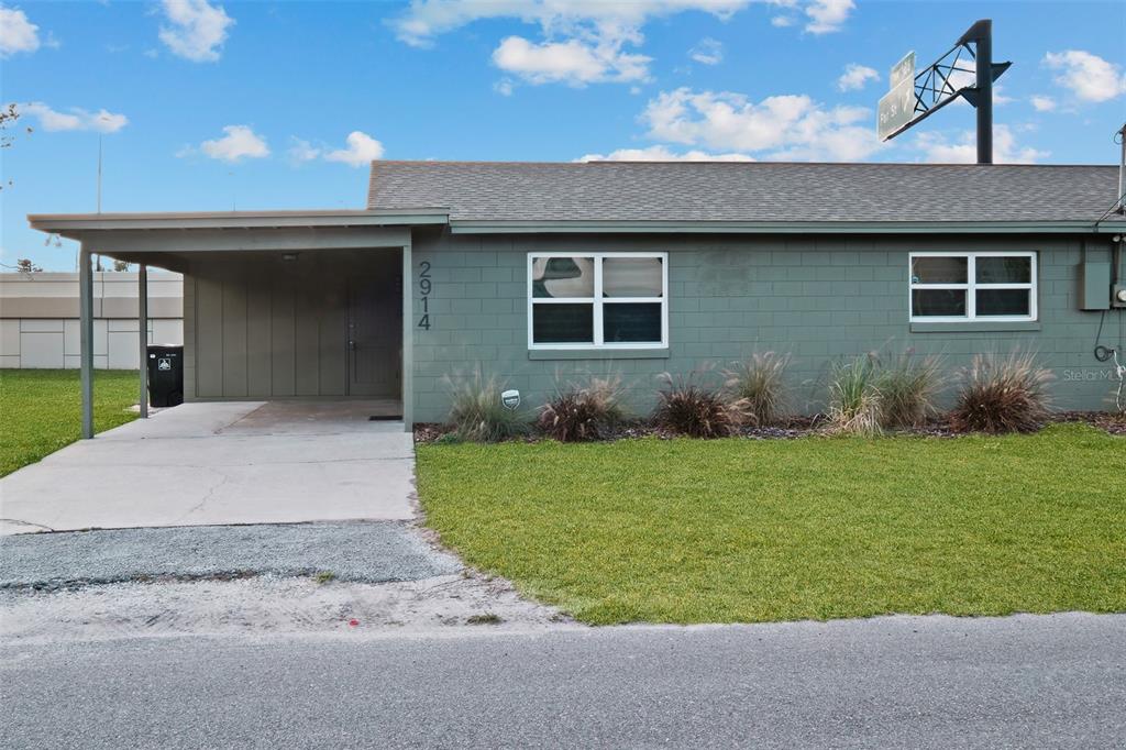 A single-story house with a green block exterior, a carport, and a front lawn — 2910 DADE AVENUE, ORLANDO, FL