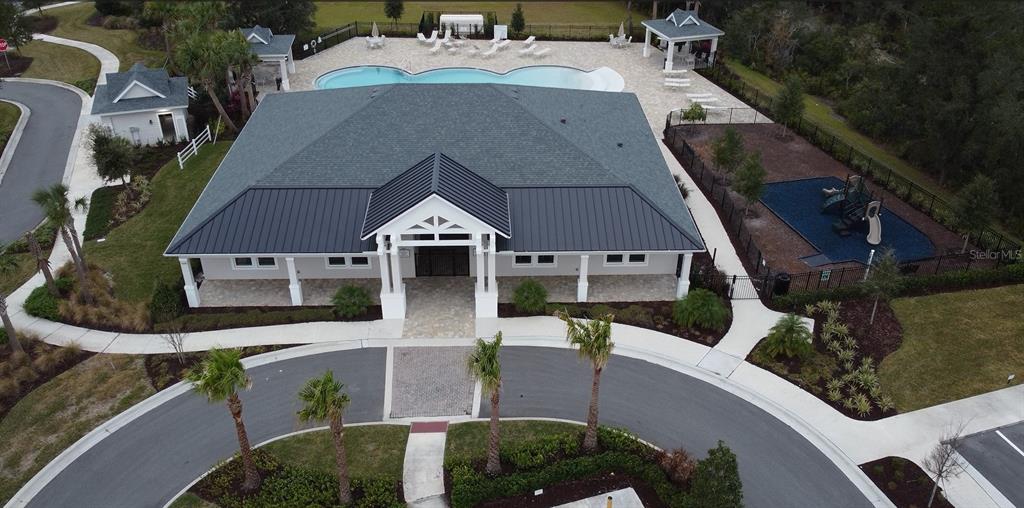 An aerial view shows a community clubhouse with a pool, playground, and surrounding landscaping — 975 MEGANO BOULEVARD, DELAND, FL