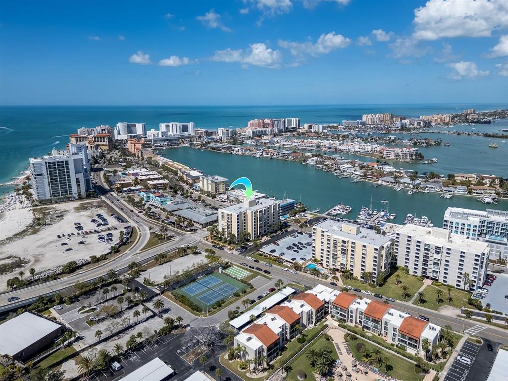 An aerial view of a coastal area featuring a multi-story apartment building with a pointer — 800 S GULFVIEW BOULEVARD UNIT 305, CLEARWATER BEACH, FL