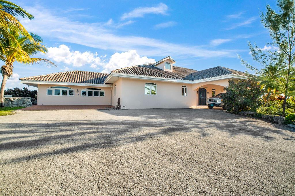 A single-story peach-colored house with a tiled roof and a large paved driveway — 42 Dunton Lane, FL