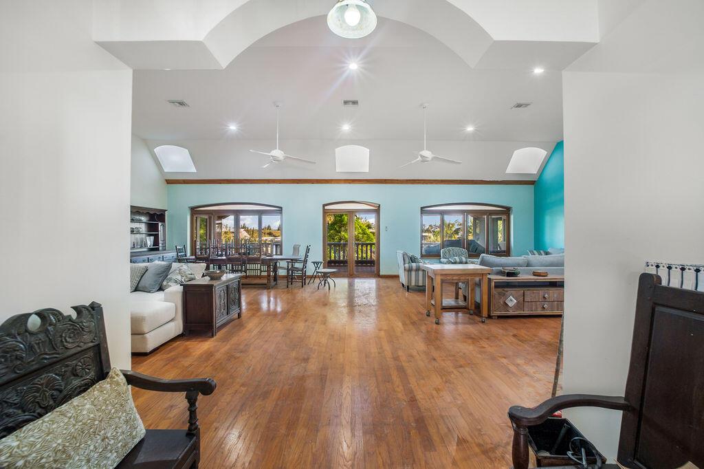 A spacious living and dining area features vaulted ceilings, hardwood floors, and large glass doors — 42 Dunton Lane, FL
