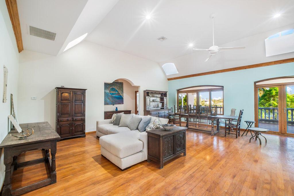 A living and dining area with vaulted ceilings, hardwood floors, and a balcony view — 42 Dunton Lane, FL