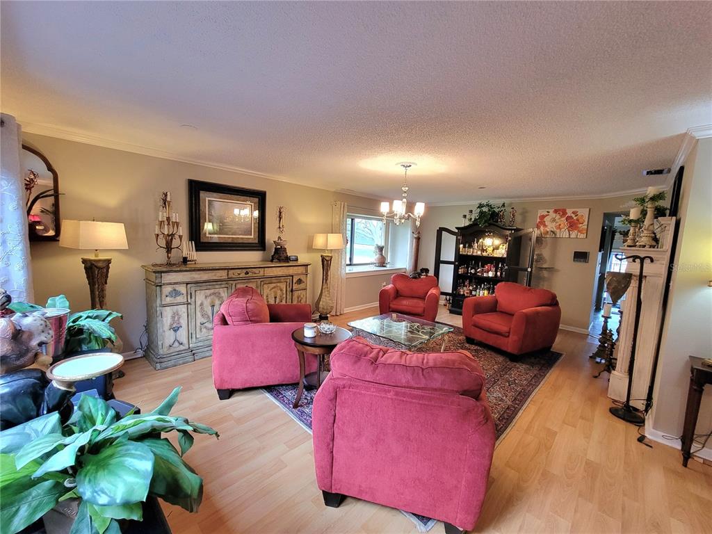 A living room features red armchairs, a glass coffee table, and a wooden sideboard — 1 CASA LOMA WAY, LAKELAND, FL