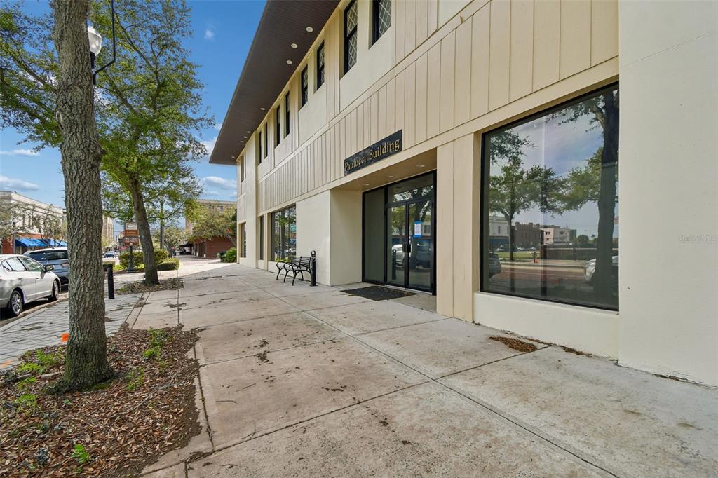The exterior of a two-story commercial building with a sidewalk and a tree in front — 201 W 1ST STREET, SANFORD, FL