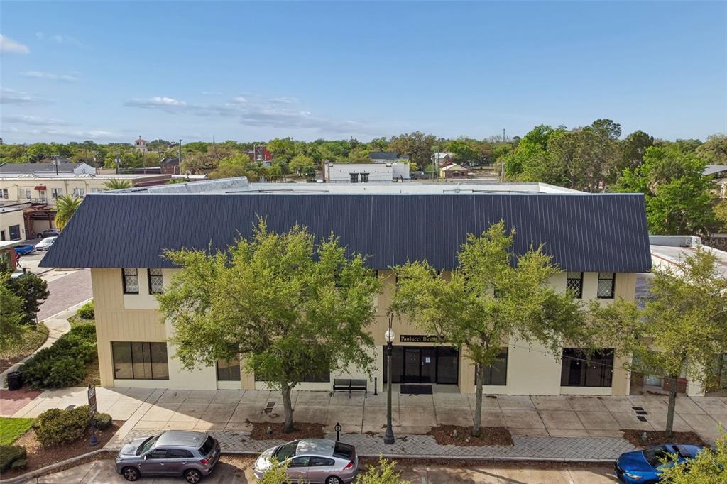 An exterior view of a two-story commercial building with a dark metal roof — 201 W 1ST STREET, SANFORD, FL