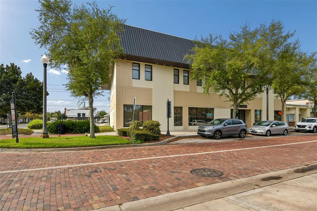 A two-story commercial building with a metal roof sits beside a brick street — 201 W 1ST STREET, SANFORD, FL
