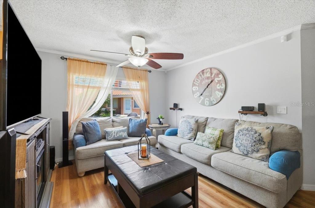 A living room features a gray sofa, a coffee table, and a large wall clock — 7902 WATERVIEW WAY, WINTER HAVEN, FL
