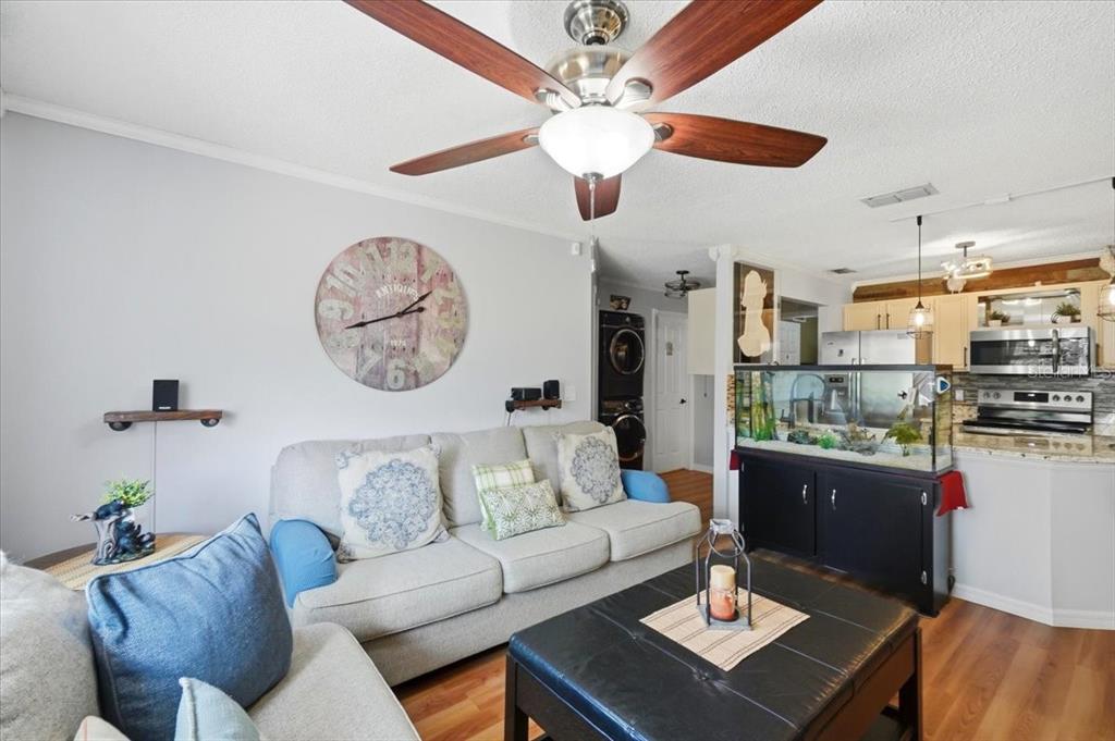 A living room features a sofa, a large wall clock, and a fish tank — 7902 WATERVIEW WAY, WINTER HAVEN, FL