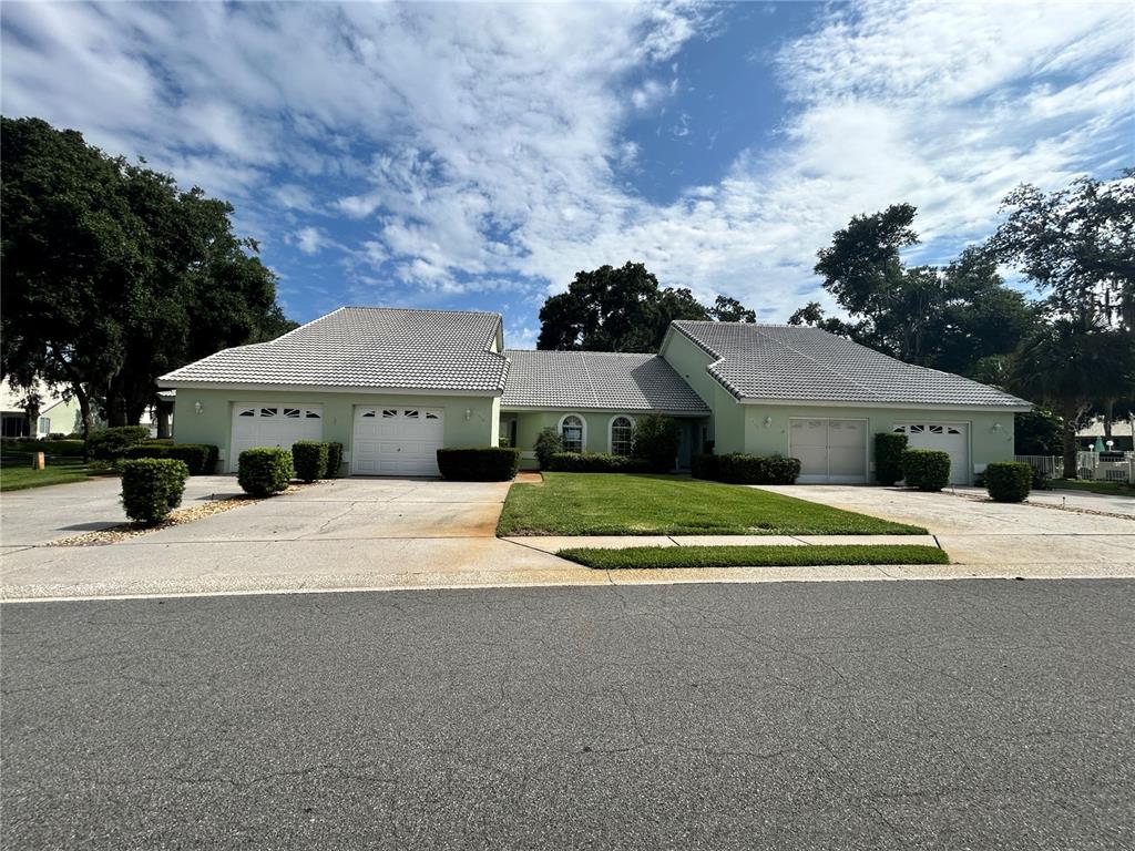 A light green house with two attached garages and a gray tiled roof — 806 WINDERMERE BOULEVARD, INVERNESS, FL