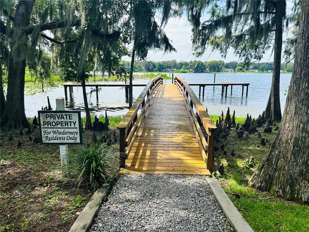 A wooden footbridge leads to a dock on a lake surrounded by trees — 806 WINDERMERE BOULEVARD, INVERNESS, FL
