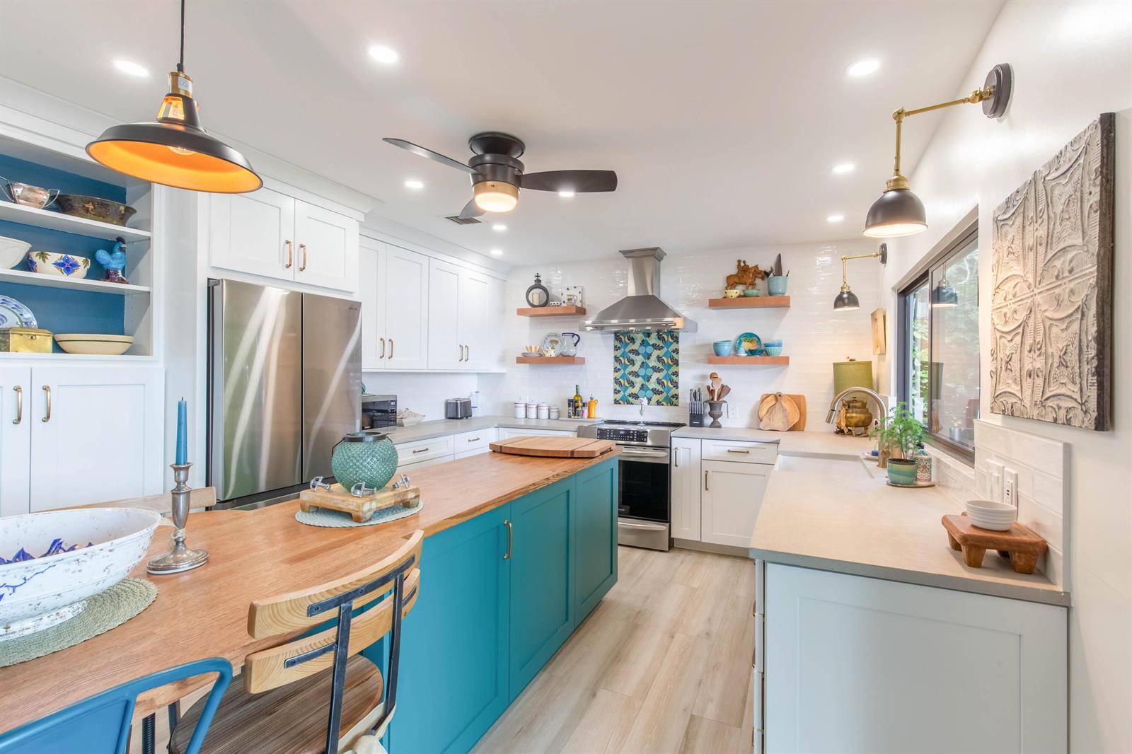 A kitchen features a teal island, white cabinetry, wood countertops, and open shelving — 1734 Harborside Circle, Wellington FL 33414, WELLINGTON, FL