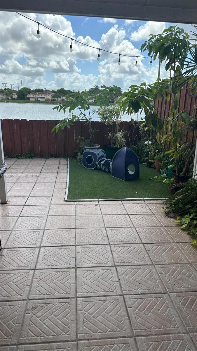 A patio features tiled flooring, a small artificial turf area, and a pet play tunnel — MIAMI, FL